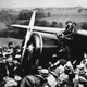 Amelia Earhart, standing on her Lockheed Vega 5B, receives the adulations of the crowd in Ireland following her solo flight across the Atlantic Ocean. (National Air and Space Museum)